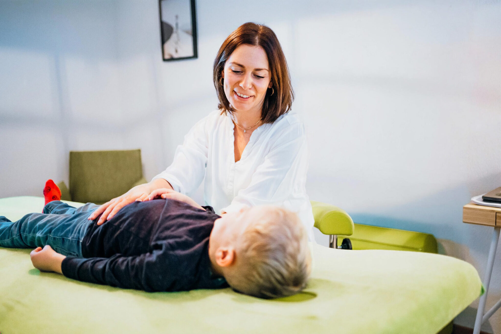Osteopathische Behandlung einer Patientin auf der Behandlungsliege